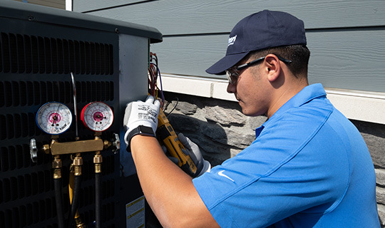 Airtron Technician Servicing An Air Conditioner