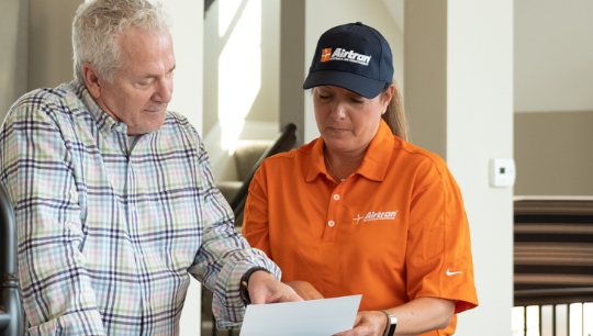 Airtron technician consulting with customer during air conditioning installation process