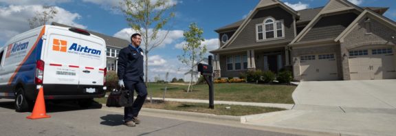 Aitron Technician Walking Away From A Service Van Towards A Home