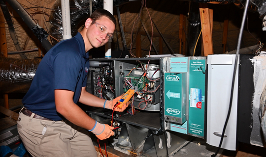 Airtron Houston service technician performing Essential HomeCare tune-up in attic