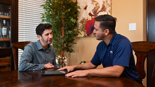 Airtron HVAC technician consulting with homeowner about air conditioning services