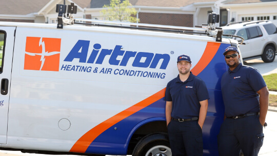 Airtron heating and air conditioning service van with two technicians in uniform