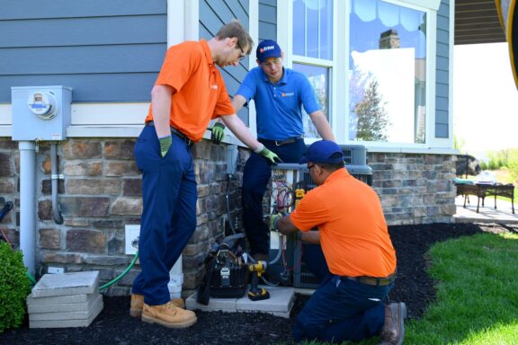 Airtron installers working on customer air conditioner