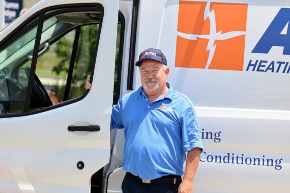 Airtron Cincinnati HVAC service technician in front of an Airtron van during a home visit