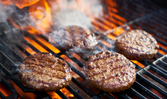 Burgers on grill with spatula from Airtron summer grill set promotion