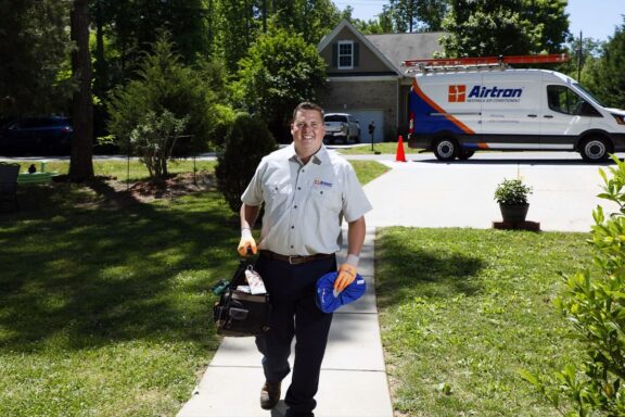 Airtron HVAC technician walking up the sidewalk during a home visit