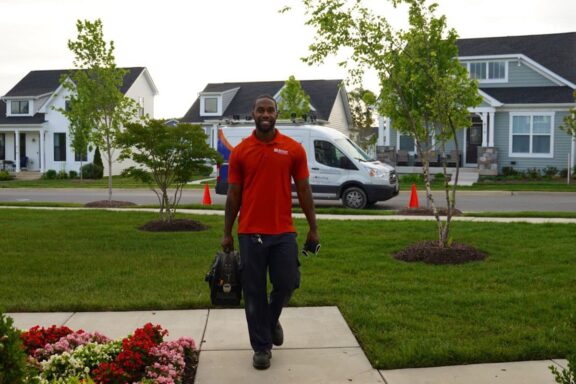 Airtron HVAC technician walking up to a home during a visit in the Mid-Atlantic region