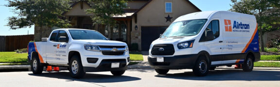 Airtron service truck and van in front of a house during a home visit