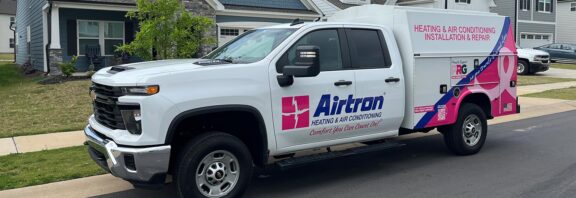 Airtron service truck outside of a customer home, featuring Pink Ribbon Good ribbon and logo